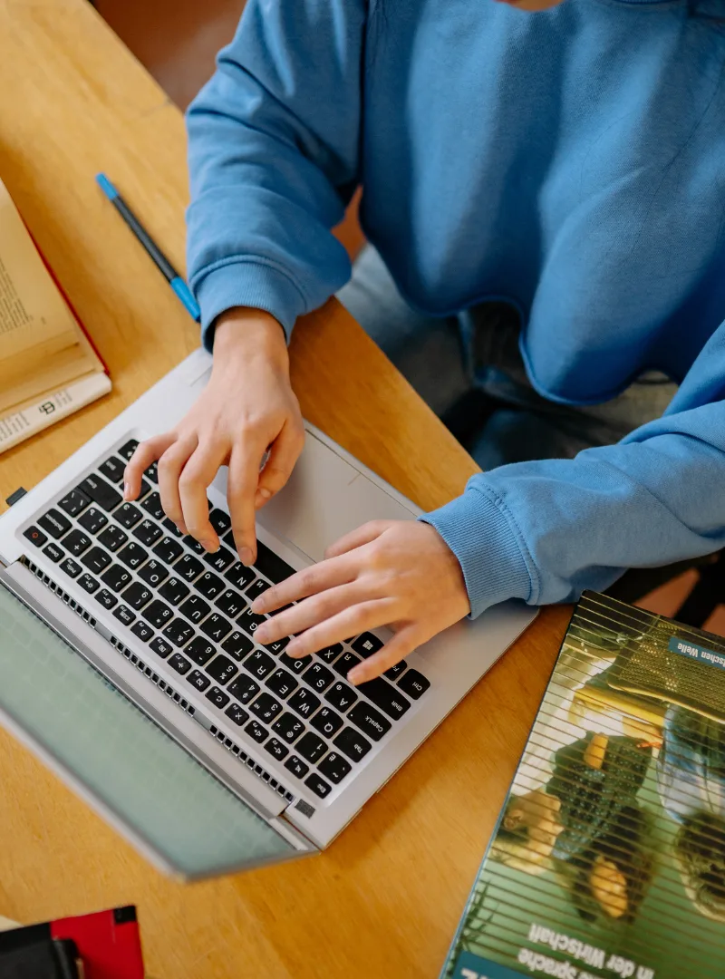 Engineer working on a laptop surrounded by electronic equipment in a technology lab
