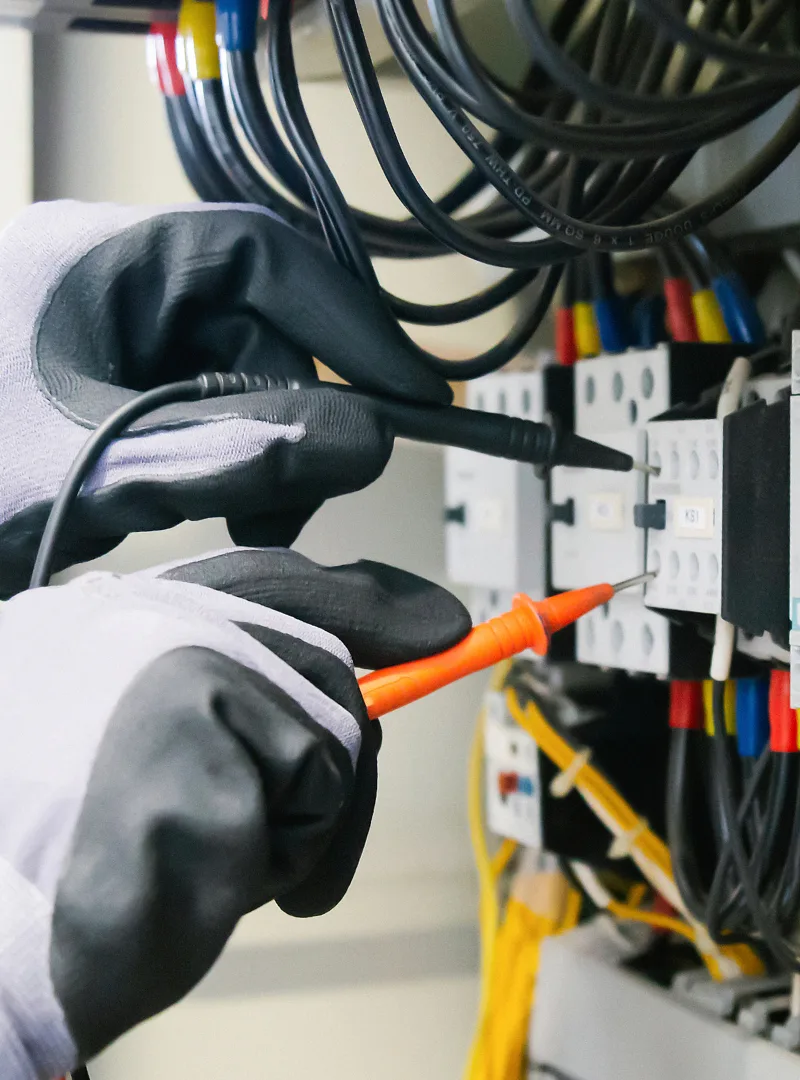 Technician working on an electronic circuit board with a precision tool